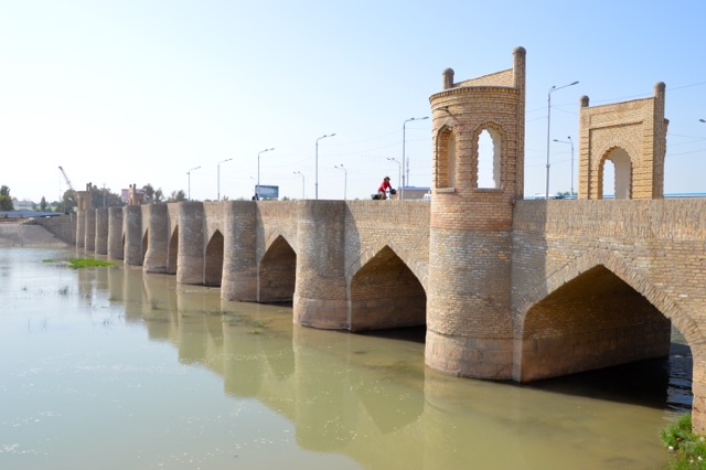 Jude riding across one of the ancient bridges in Qarshi.